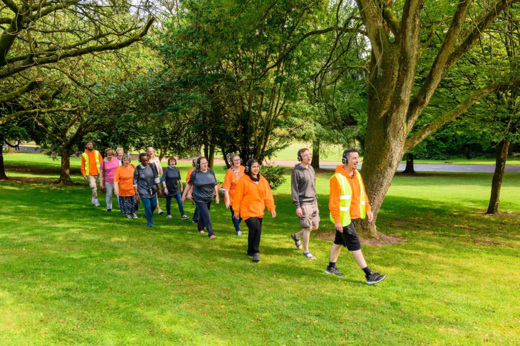 A walking choir singing together in a park