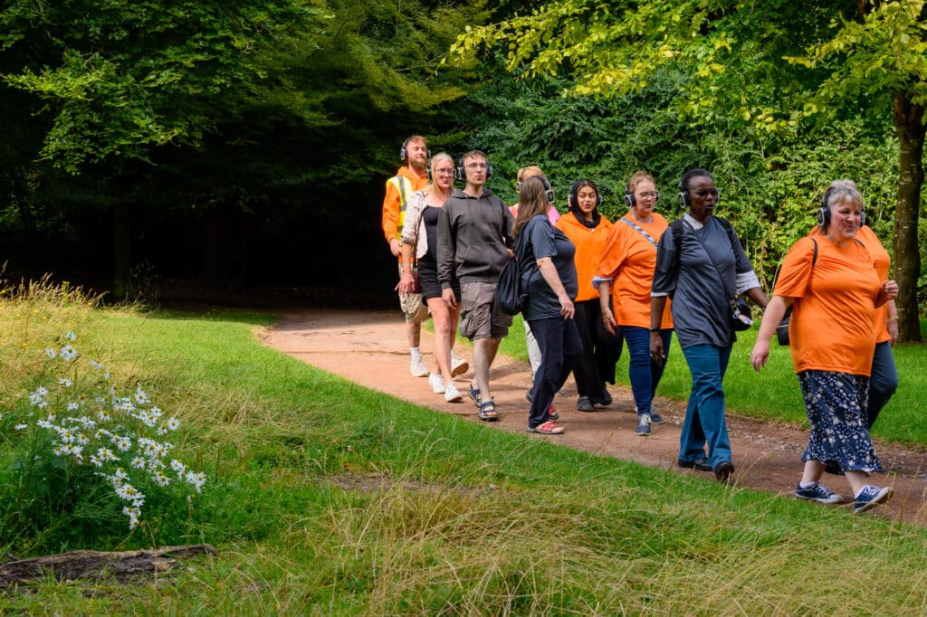 Walking choir-30 Walking choir members singing on a woodland path
