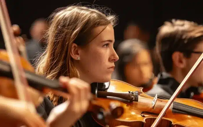 musicians in a community orchestra sitting attentively in their seats with their instruments ready for rehearsal