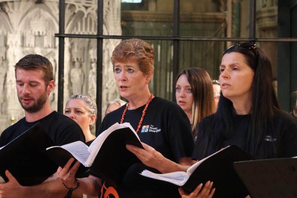 TPSC Cheltenham Summer Extravaganza Choir members singing from their music at a summer concert