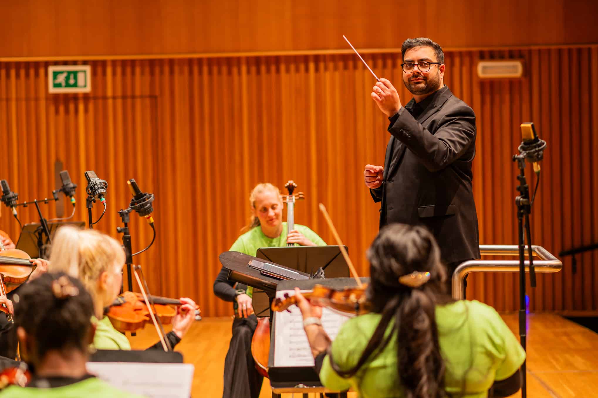 Conductor waving his baton to an orchestra.
