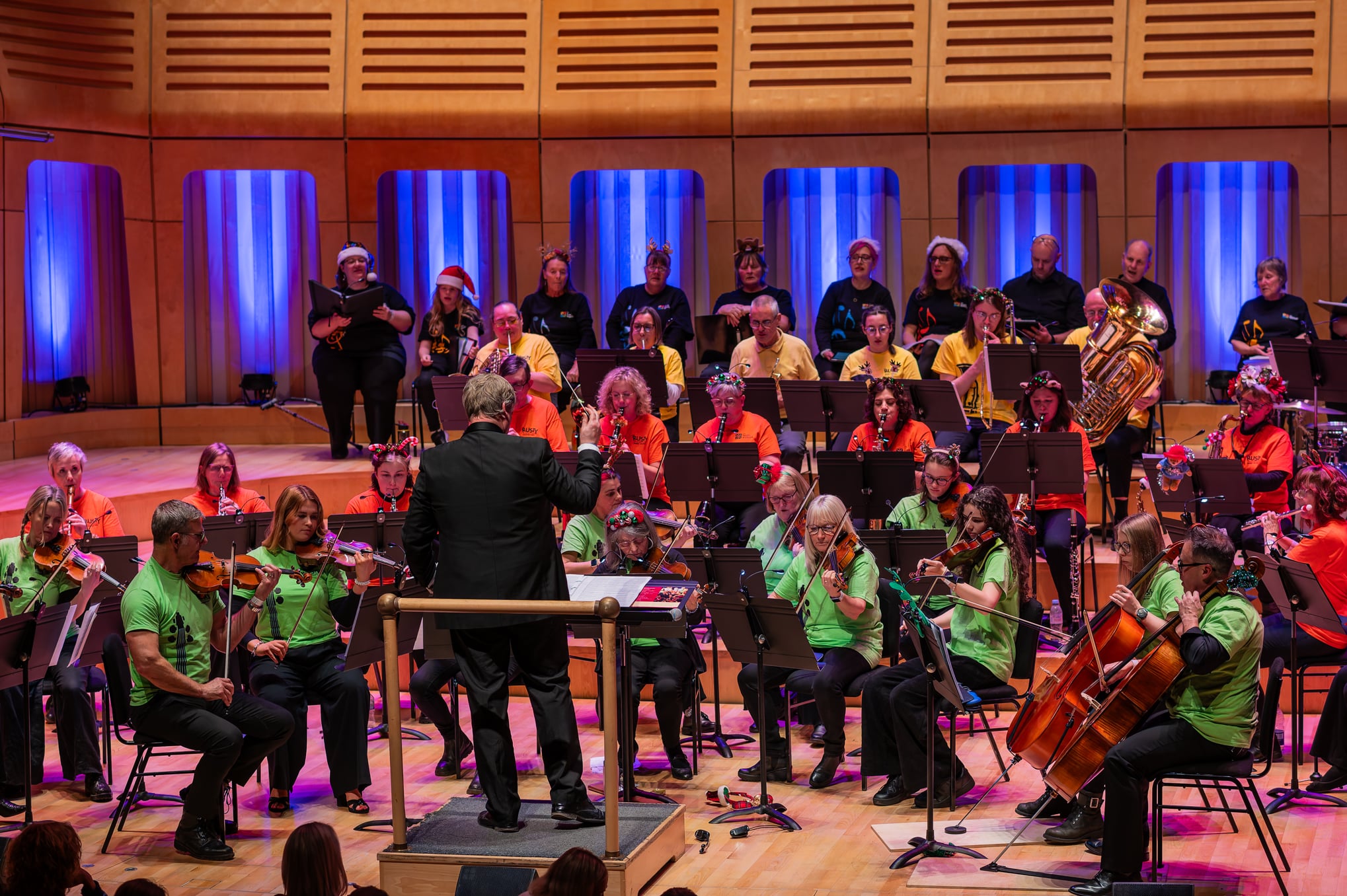 The People's Orchestra, The Rusty Players Orchestra and The People's Show Choir performing on stage at Dora Stoutsker Hall.