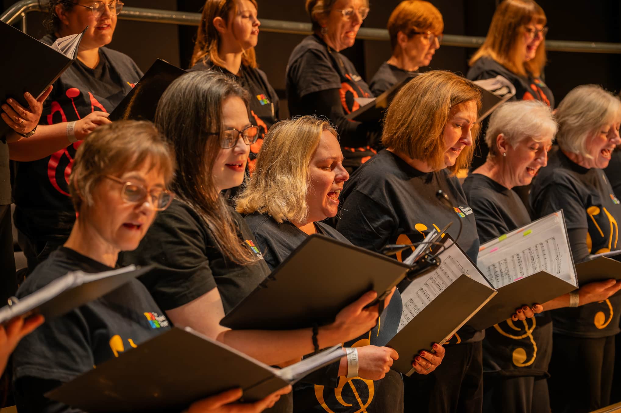 The People's Show Choir Cardiff and Newport singing on stage.