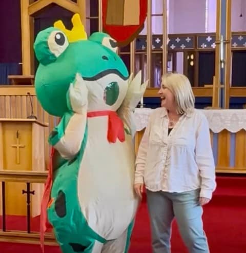 Singer wearing a costume next to choir leader.