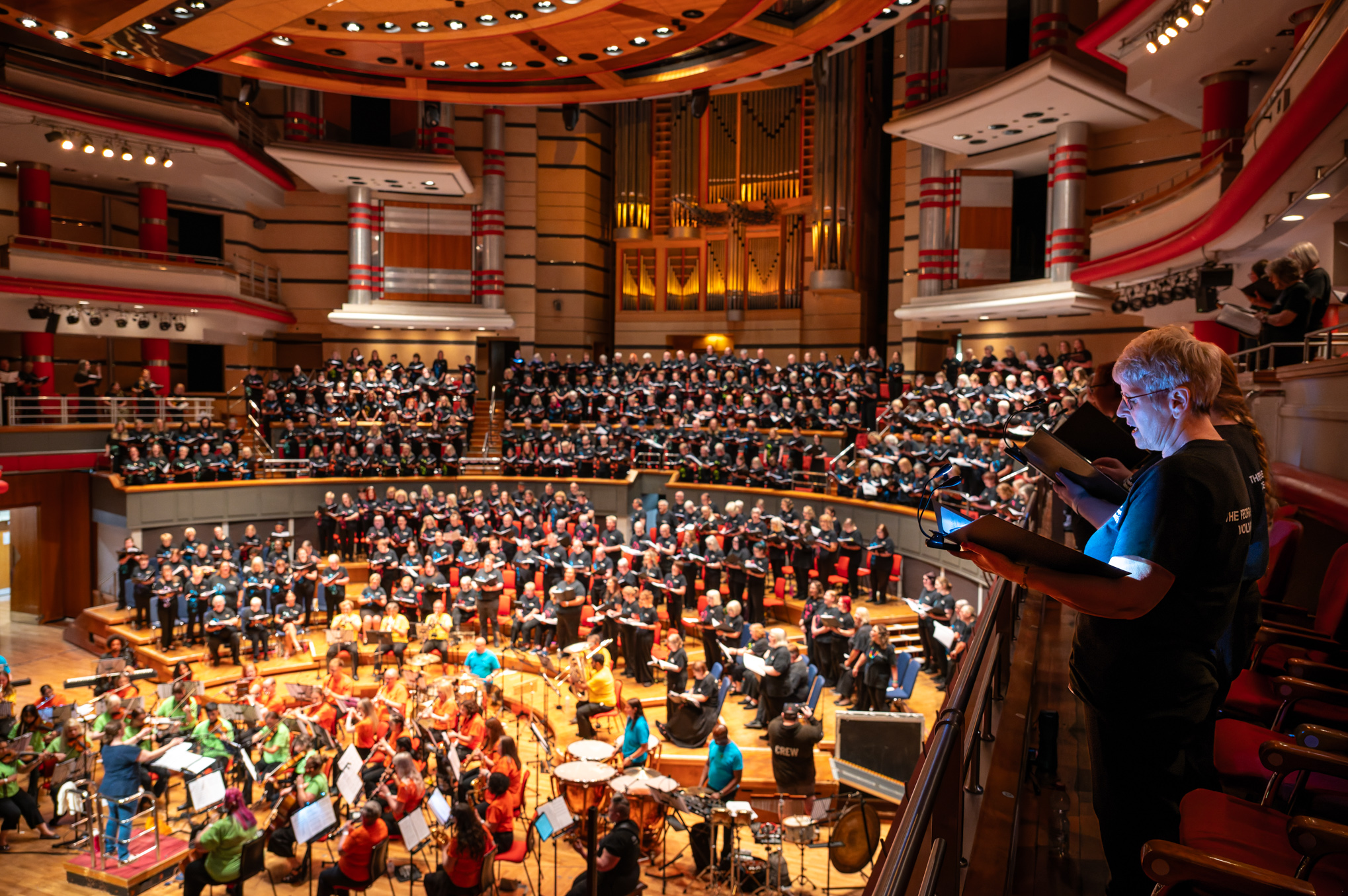 The People's Orchestra and The People's Show Choir rehearsing together inside Birmingham Symphony Hall.