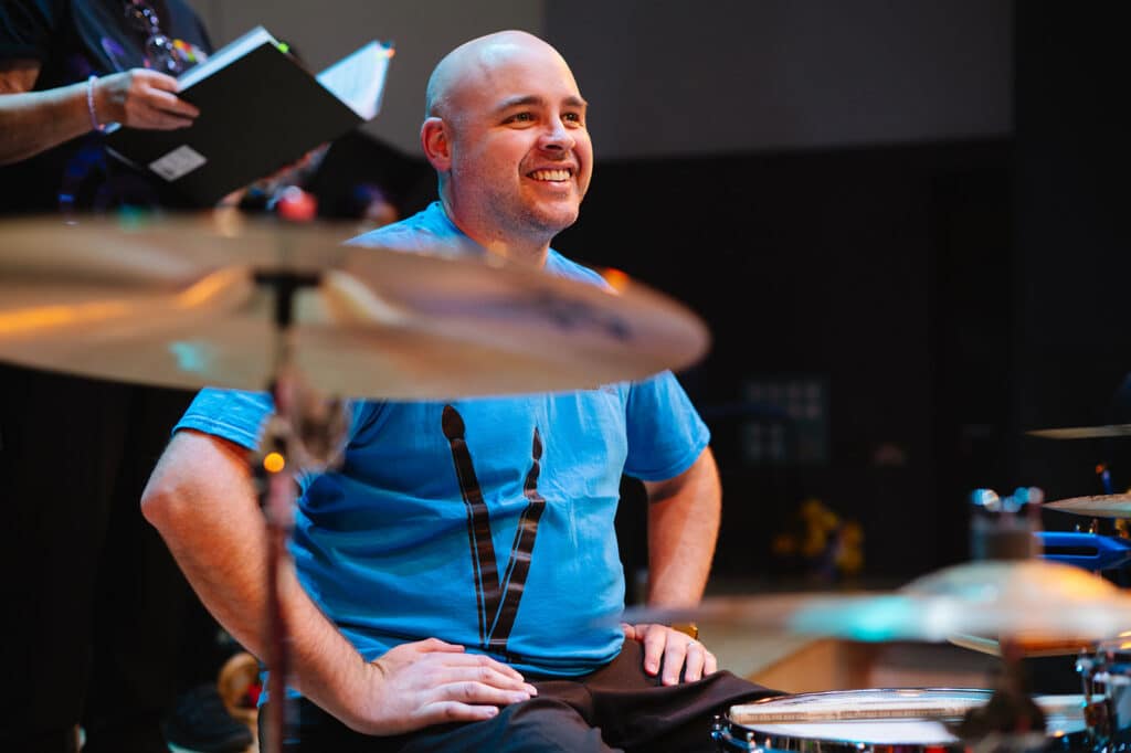 A smiling drummer performing at Birmingham Town Hall